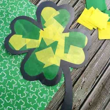 Stained glass clover craft make with tissue paper and posterboard.